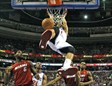 Michael Carter-Williams se cuelga del aro ante la mirada de LeBron James